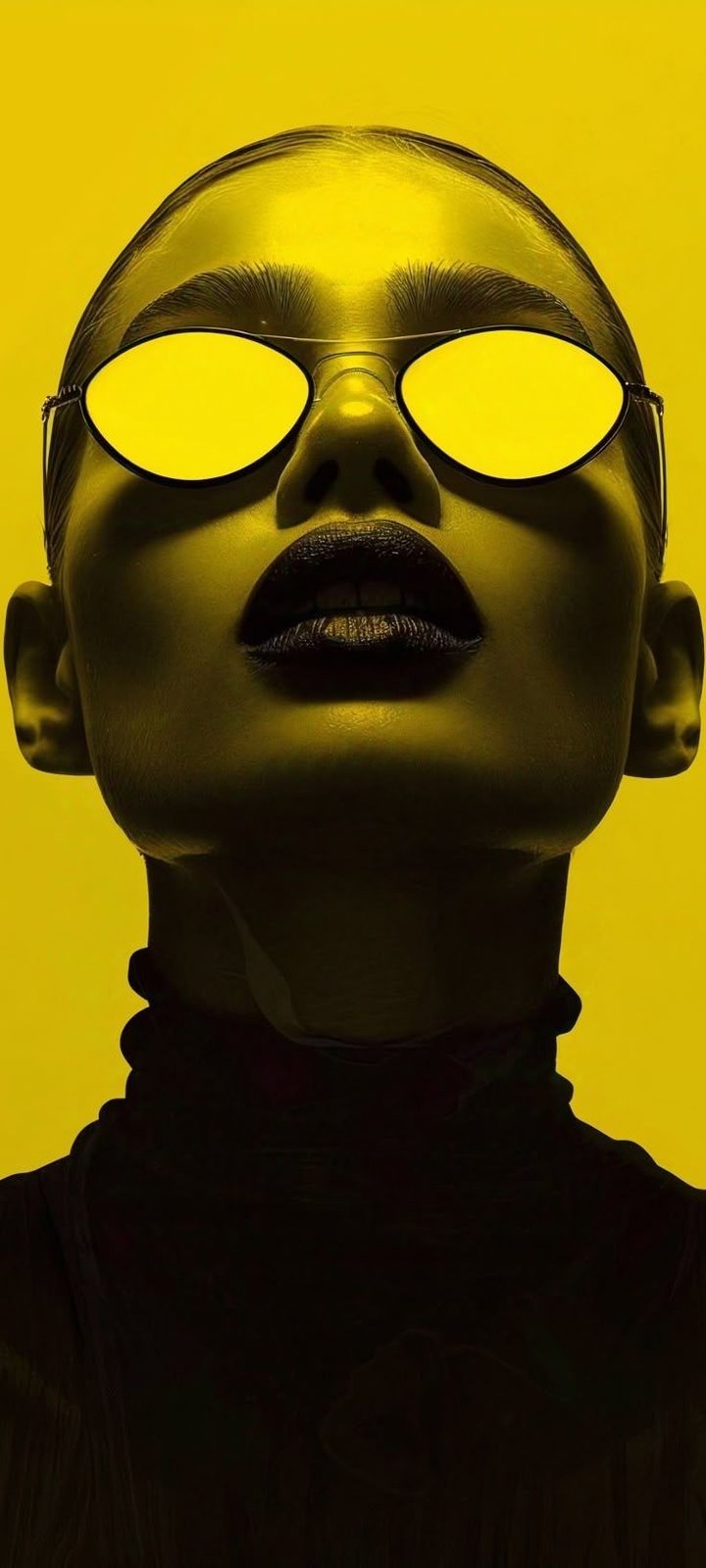 Portrait lit entirely in gold, tinted round sunglasses and a black turtleneck